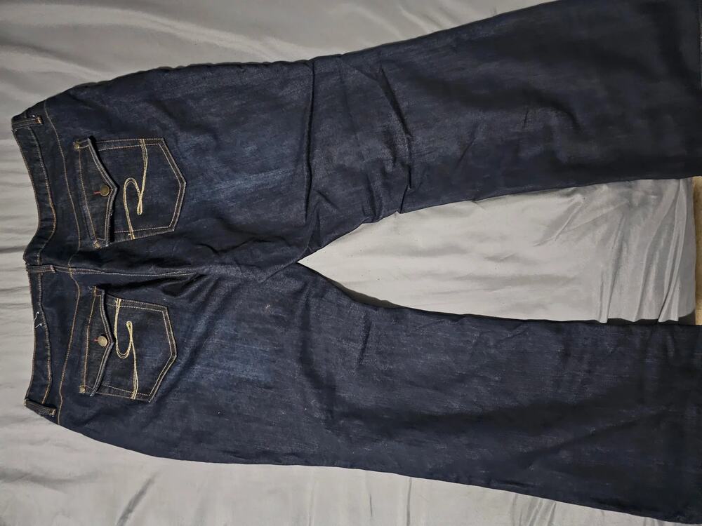 Dark wash denim jeans with contrast stitching flap back pockets